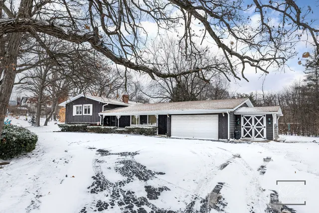 a front view of a house with a yard covered in snow
