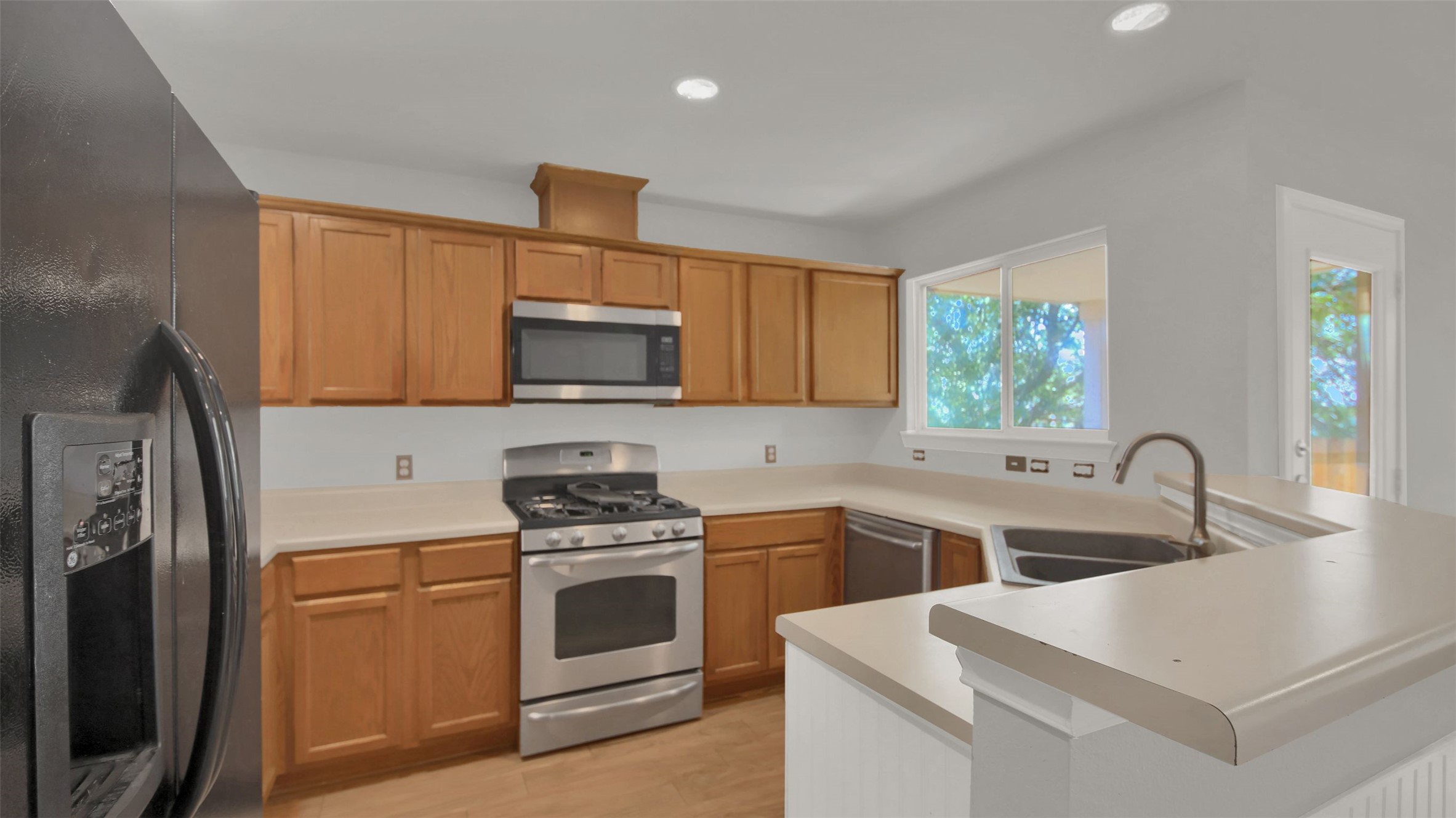 1609 Harness Raceway Street Pflugerville, TX 78660 - Photo 13 of 32 A well-equipped kitchen features honey-toned cabinetry and essential stainless steel appliances.