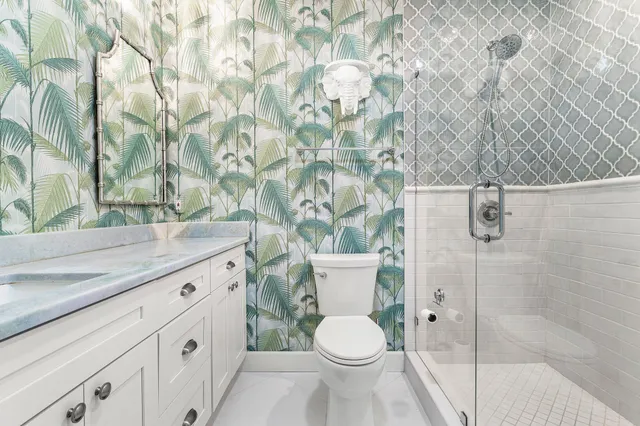 a bathroom with a granite countertop toilet and a sink