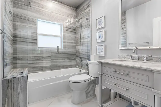 a bathroom with a granite countertop toilet a sink and a bathtub