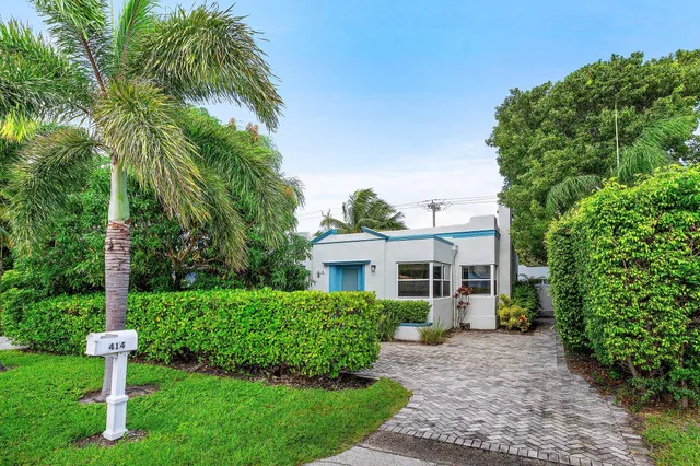 a front view of a house with a yard and trees