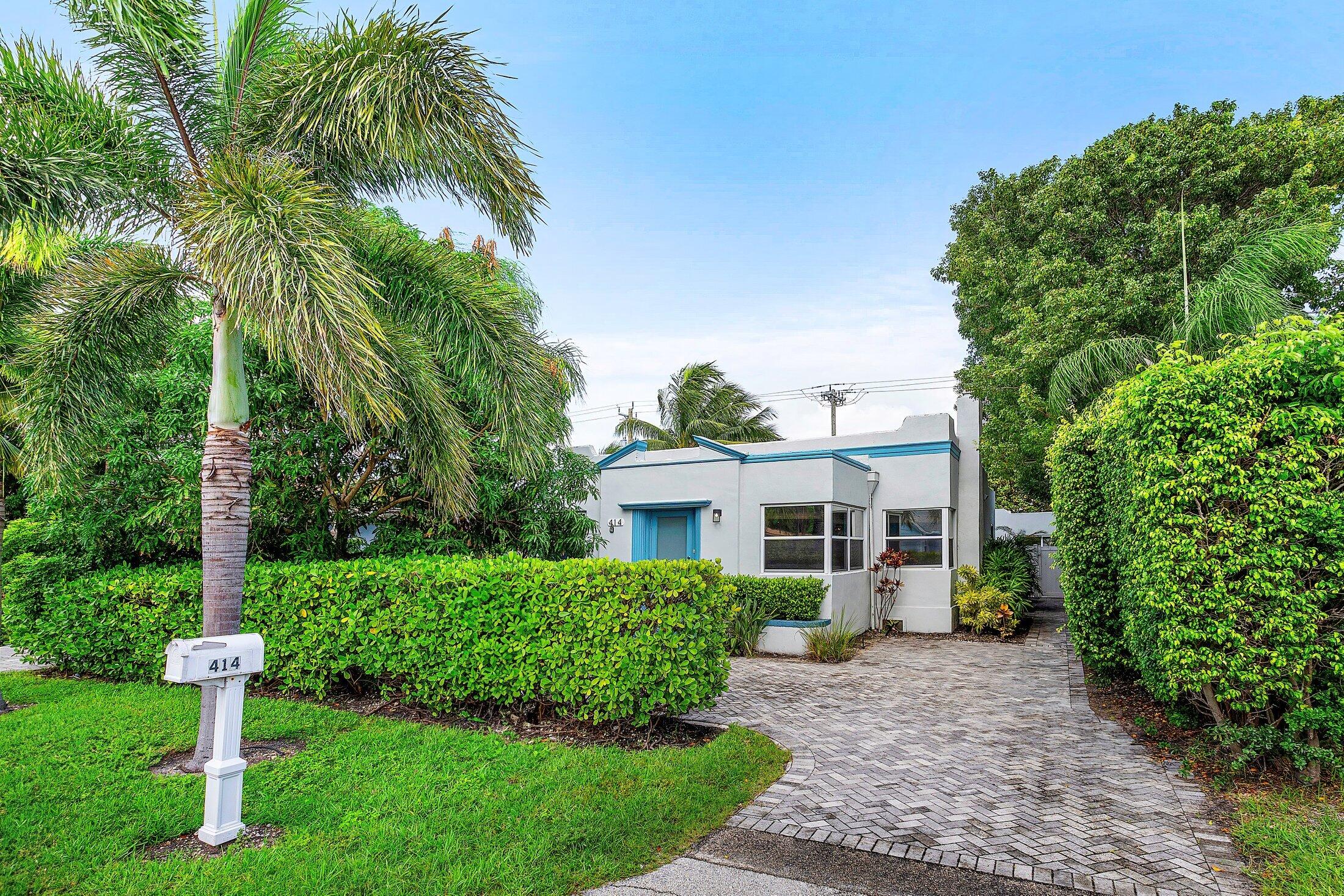 414 Northeast 7th Avenue Delray Beach, FL 33483 - Photo 2 of 29 a front view of a house with a yard and trees