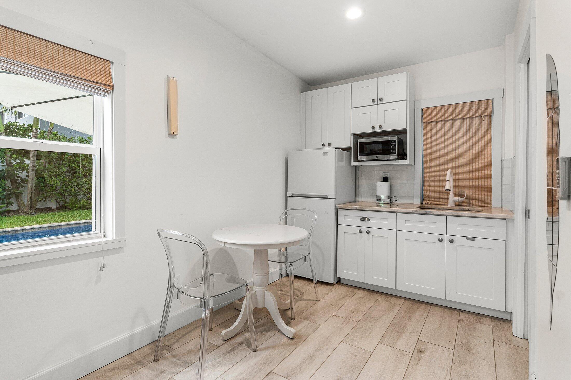 414 Northeast 7th Avenue Delray Beach, FL 33483 - Photo 25 of 29 a kitchen with sink cabinets and chairs