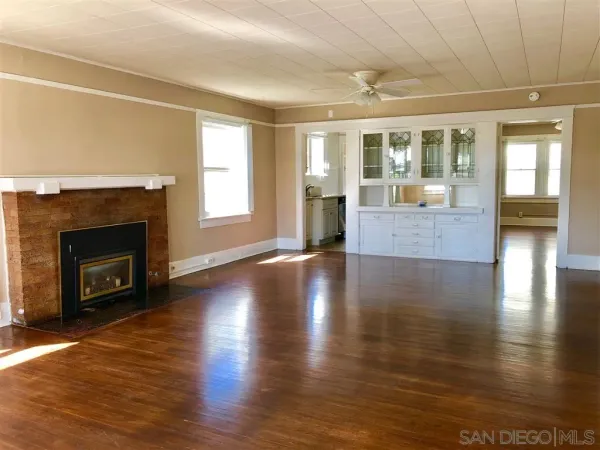 a view of a livingroom with wooden floor and a fireplace