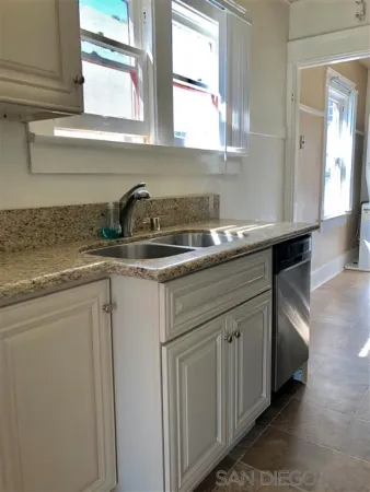 a kitchen with stainless steel appliances granite countertop a sink and a stove next to a window