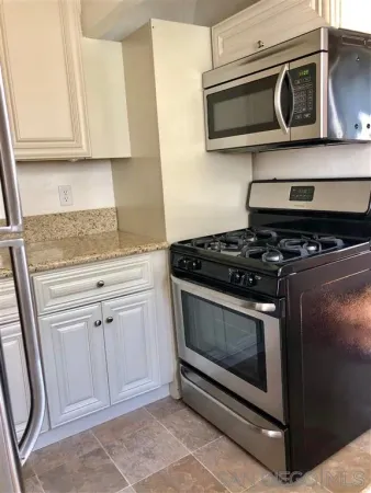 a kitchen with white cabinets and stainless steel appliances