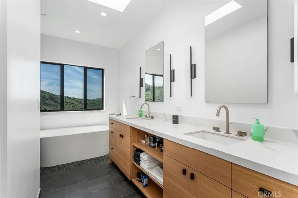 a bathroom with a double vanity sink mirror and shower