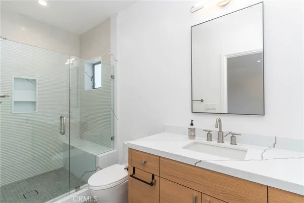 a bathroom with a sink a toilet and shower