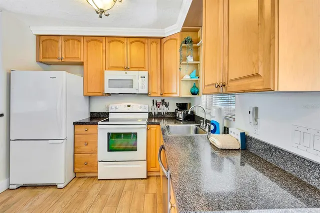 a kitchen with stainless steel appliances granite countertop a refrigerator a stove top oven a sink and dishwasher