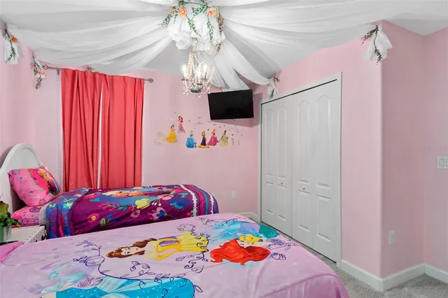 a bedroom with a bed and a flat tv screen on dresser