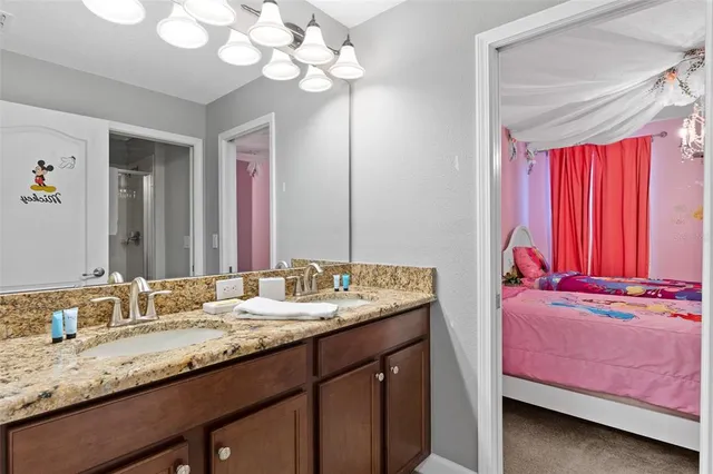 a bathroom with a granite countertop sink a large mirror and shower
