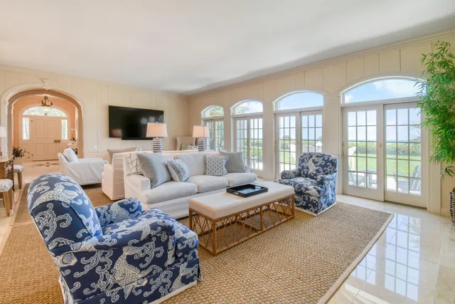 a bedroom with a large bed a flat tv screen and white walls