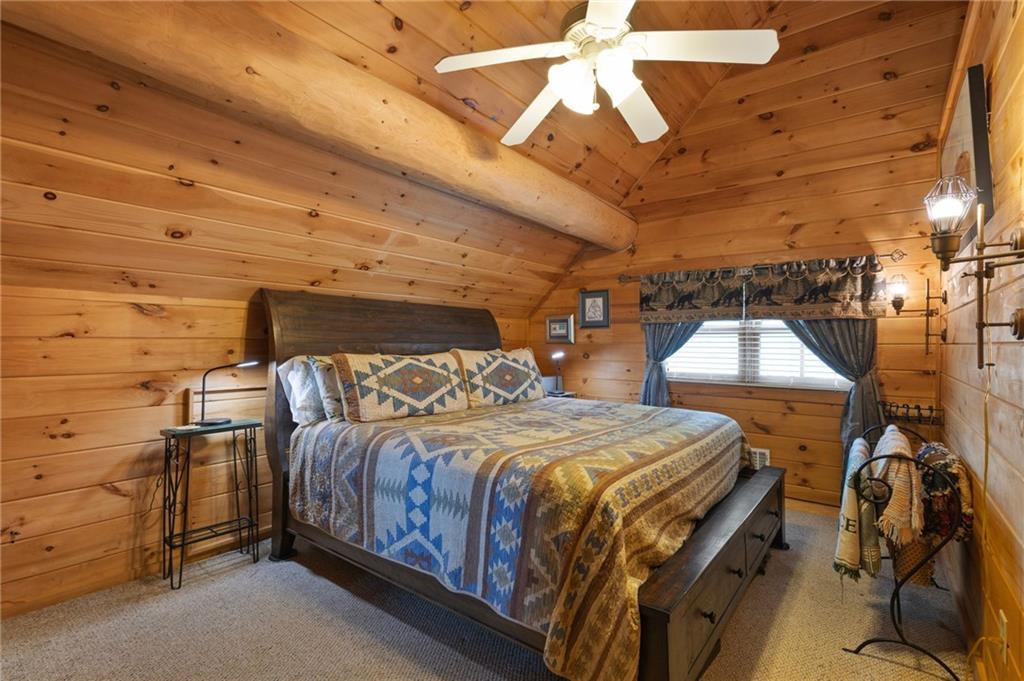 103 Twin Lakes Road Blue Ridge, GA 30513 - Photo 41 of 71 a bedroom with a bed and a chandelier