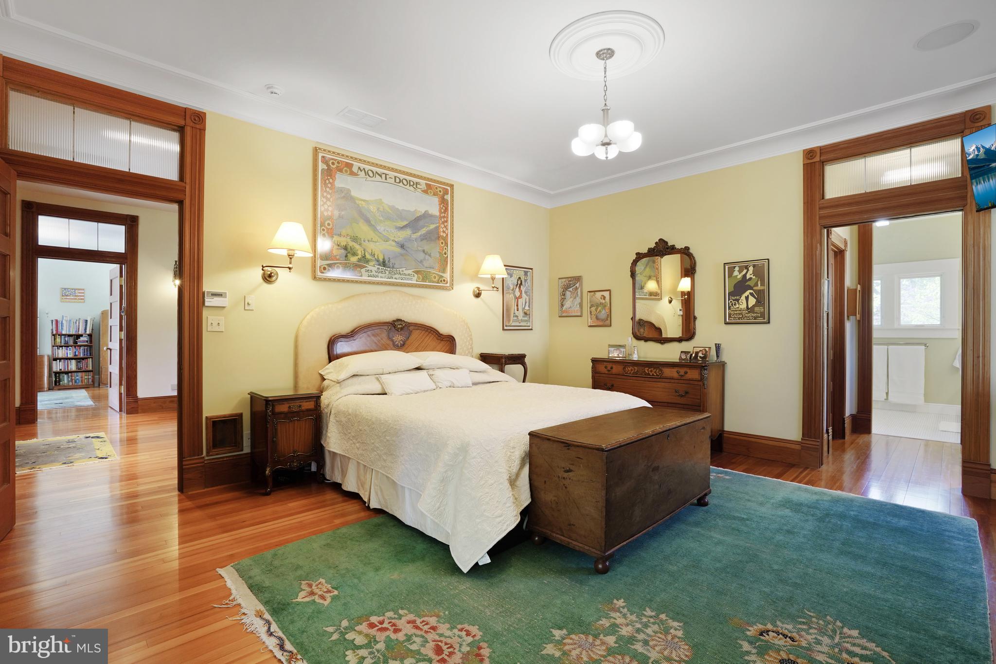 5402 Tuscarawas Road Bethesda, MD 20816 - Photo 23 of 55 a spacious bedroom with a bed a dresser and a chandelier