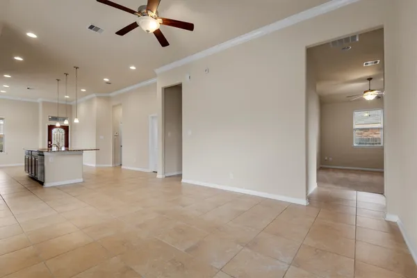 a view of an empty room and kitchen view