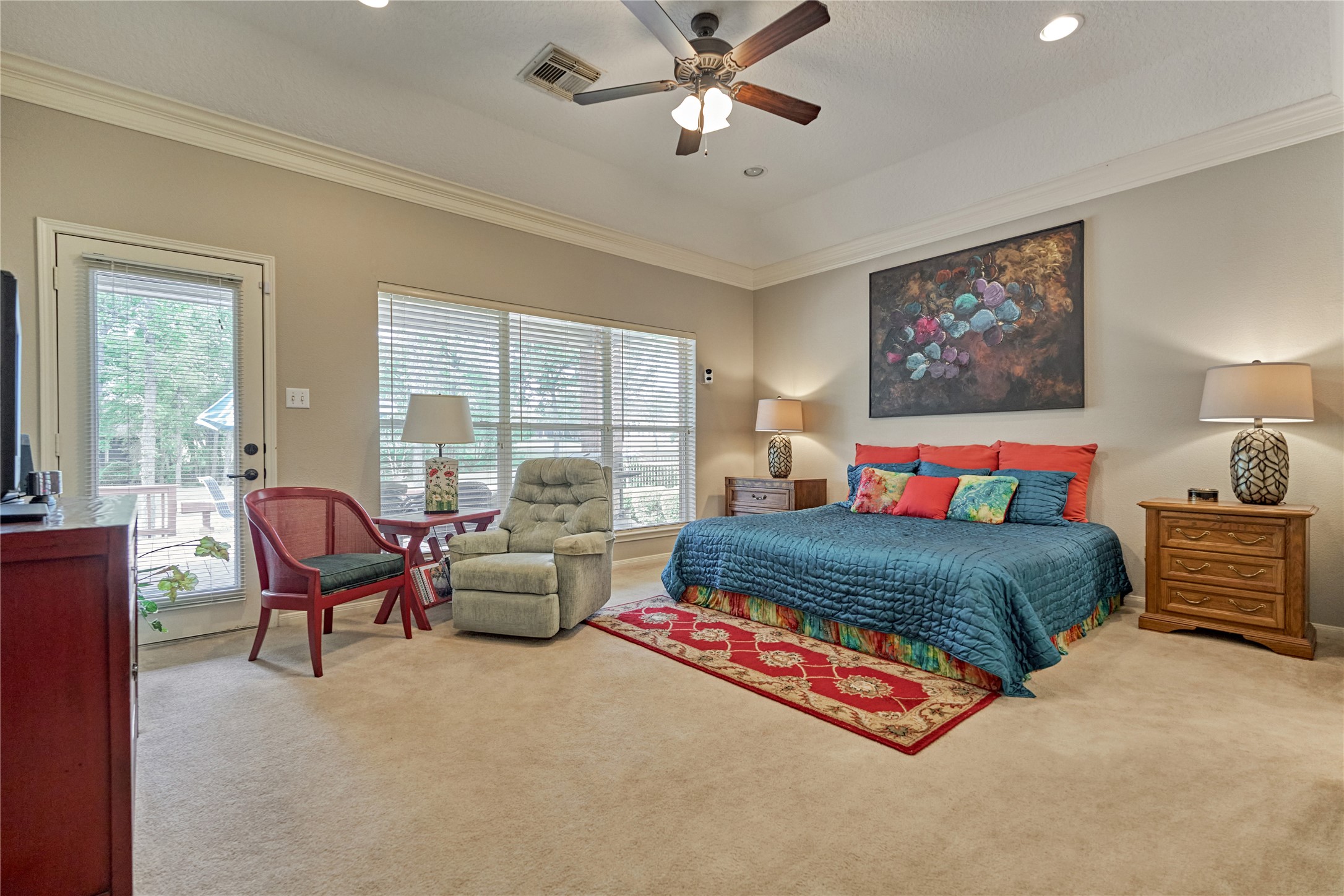 197 Monterrey Road East Montgomery, TX 77356 - Photo 20 of 50 The expansive owner’s suite features soaring ceilings and direct private access to the back patio and deck, creating a seamless indoor-outdoor retreat.