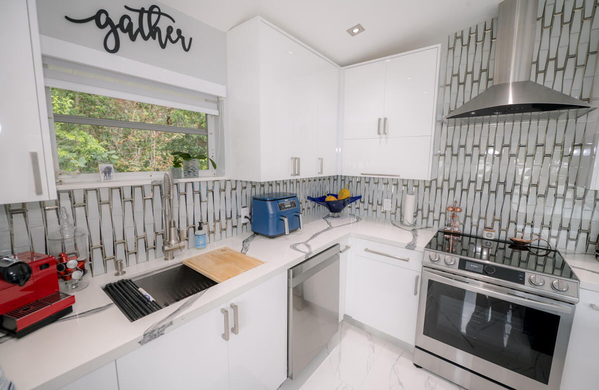 1016 Gibraltar Road Key Largo, FL 33037 - Photo 14 of 39 a kitchen with a stove and white cabinets