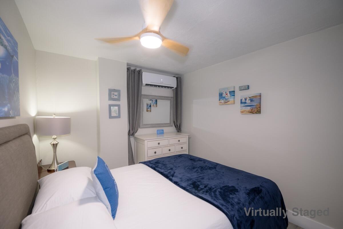 1016 Gibraltar Road Key Largo, FL 33037 - Photo 30 of 39 a bedroom with a bed and a chandelier