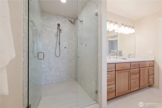 a bathroom with a double vanity sink mirror and shower