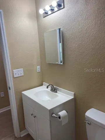 a bathroom with a sink a toilet and mirror