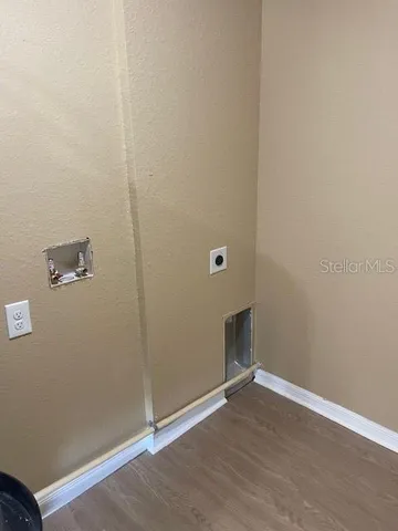 an empty room with wooden floor and entrance