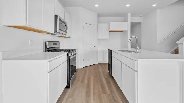 a kitchen with stainless steel appliances granite countertop a sink and a stove