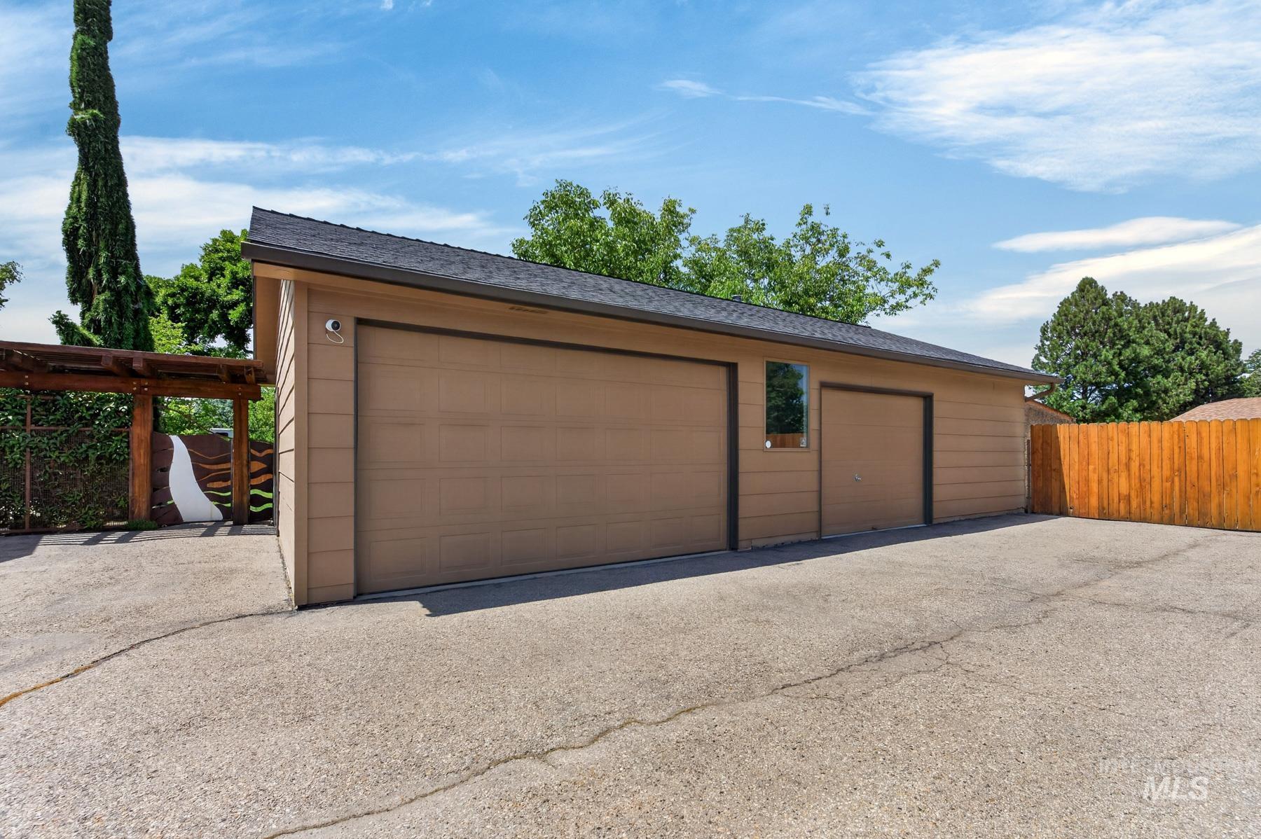 9622 Delaware Street Boise, ID 83709 - Photo 46 of 48 Two-car garage with tan siding, asphalt shingle roofing, and concrete driveway