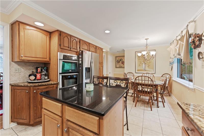 4914 Simmons Circle Export, PA 15632 - Photo 13 of 33 a kitchen with granite countertop a stove a sink a dining table and chairs