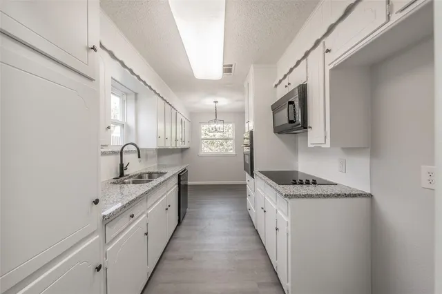 a kitchen with stainless steel appliances a sink stove top oven and cabinets
