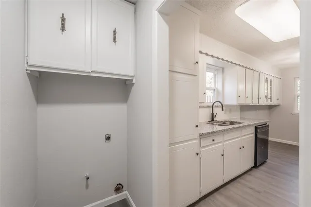 a kitchen with white cabinets and sink