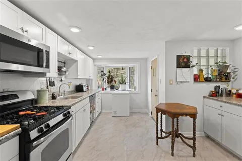 a kitchen with stainless steel appliances a stove a sink cabinets and a refrigerator
