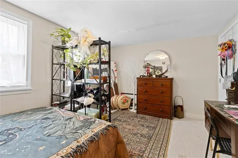 a bedroom with a bed a mirror and couch