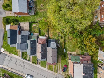 an aerial view of a city with lots of residential buildings and mountain view in back