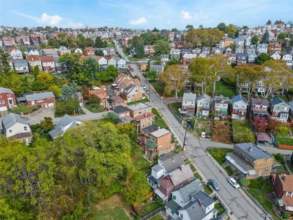 an aerial view of residential houses with outdoor space and street view