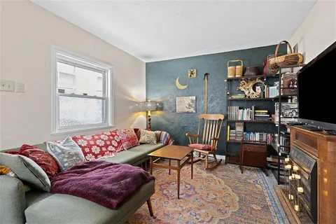 a living room with furniture a flat screen tv and a window