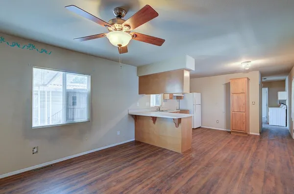 a kitchen with a sink cabinets stainless steel appliances and wooden floor