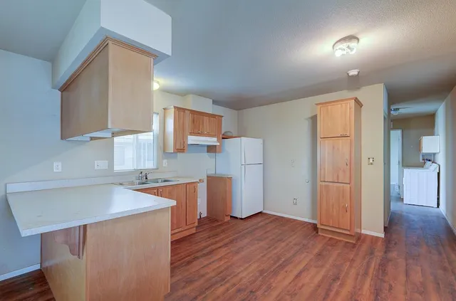 a kitchen with wooden floors and wooden cabinets
