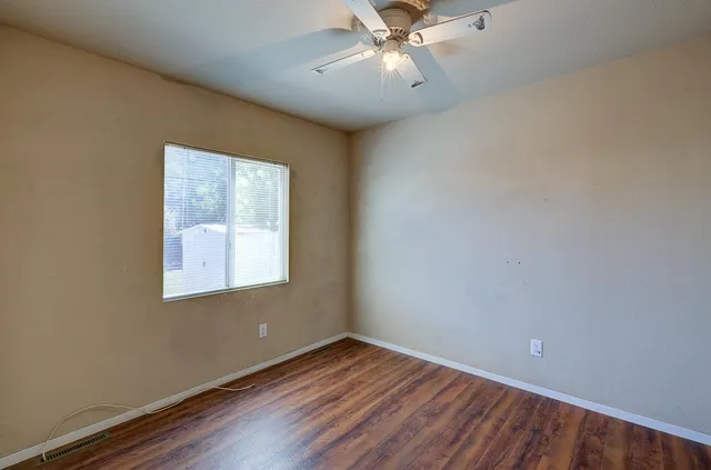a view of an empty room with wooden floor