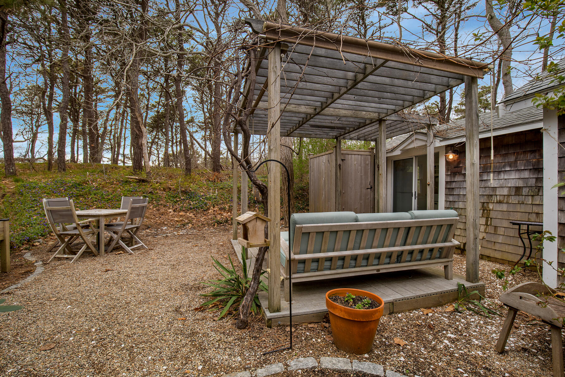 82 Shore Road, Unit 9 Truro, MA 02666 - Photo 23 of 36 a backyard of a house with barbeque oven table and chairs