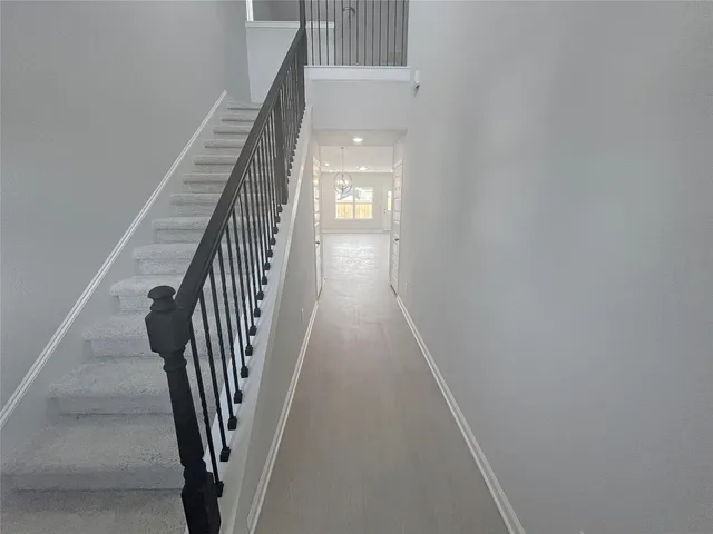 a view of a hallway with wooden floor and stairs