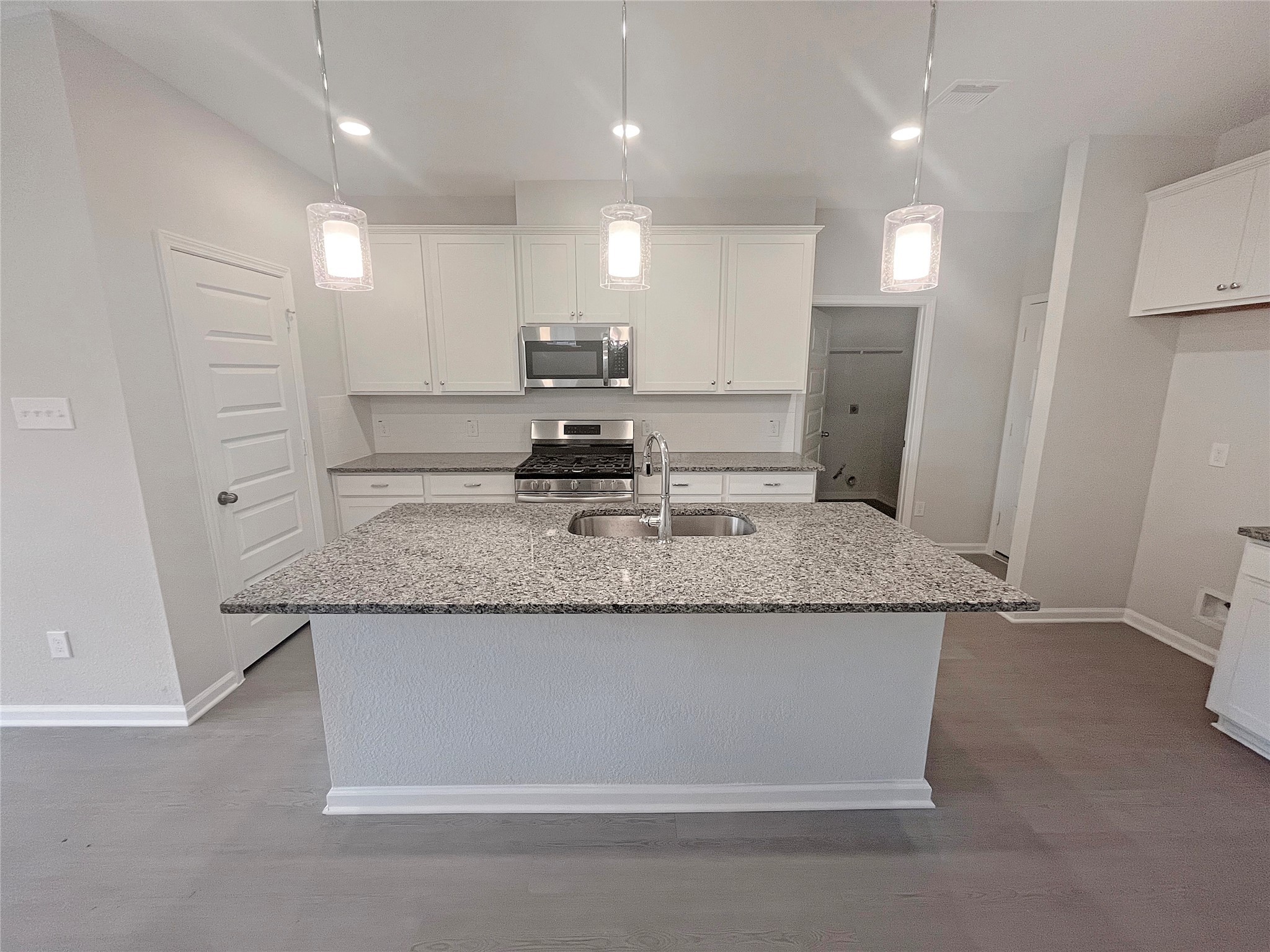 9765 Enclave Ridge Road Willis, TX 77318 - Photo 4 of 18 a kitchen with kitchen island granite countertop counter top space a sink stainless steel appliances and cabinets