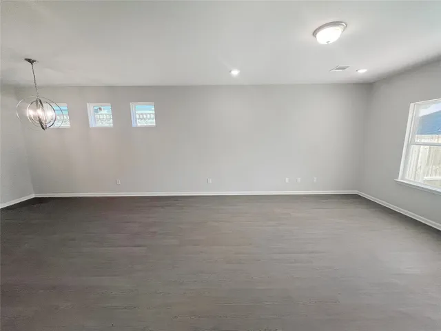 an empty room with stairs and windows