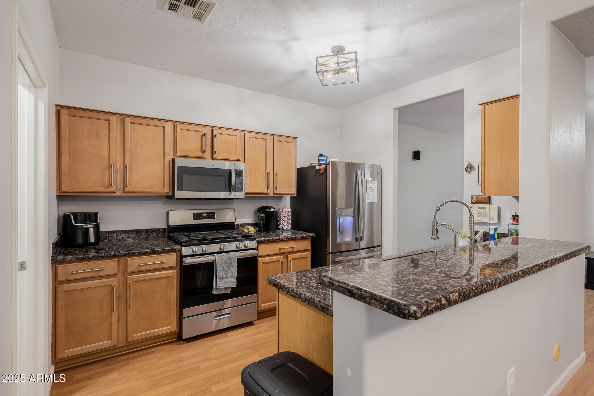 241 Mountain View Road San Tan Valley, AZ 85143 - Photo 26 of 62 a kitchen with stainless steel appliances granite countertop a stove a sink dishwasher a refrigerator and white cabinets with wooden floor