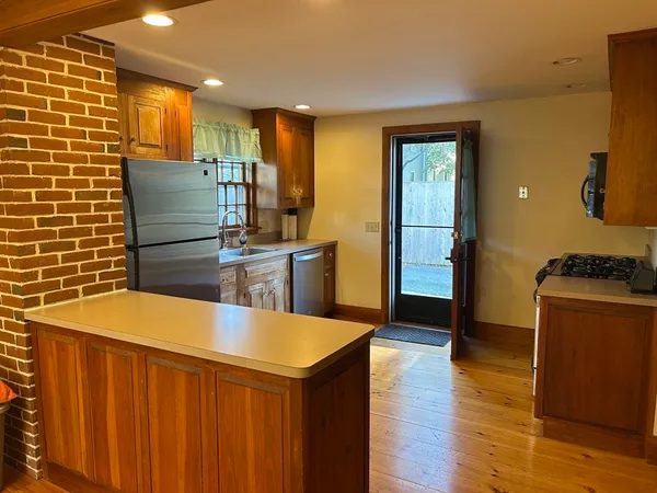 a kitchen with stainless steel appliances kitchen island granite countertop a table and chairs
