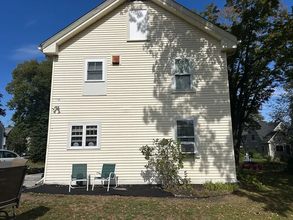 a view of a house with a yard and large tree