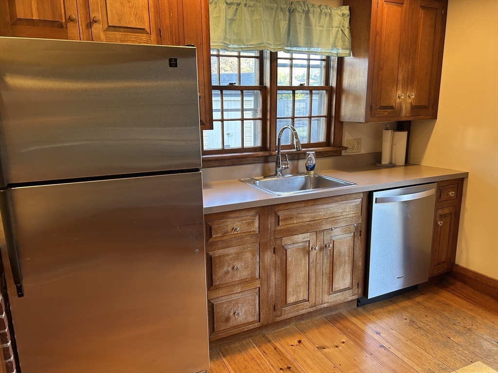 33 Woodland Street, Unit 1 Newburyport, MA 01950 - Photo 3 of 11 a kitchen with stainless steel appliances granite countertop a sink stove and refrigerator