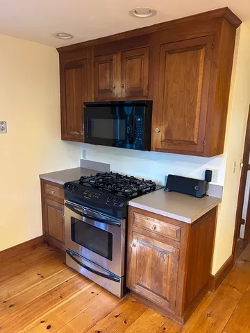a kitchen with granite countertop a stove and a microwave