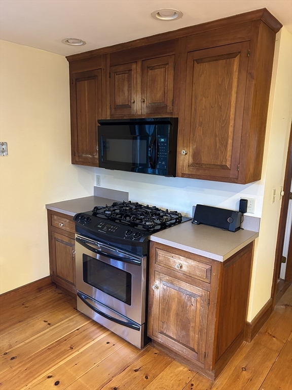 33 Woodland Street, Unit 1 Newburyport, MA 01950 - Photo 4 of 11 a kitchen with granite countertop a stove and a microwave
