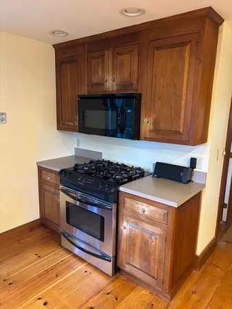 a kitchen with granite countertop a stove and a microwave