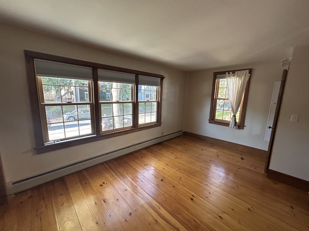 33 Woodland Street, Unit 1 Newburyport, MA 01950 - Photo 8 of 11 an empty room with wooden floor and windows